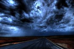 Image of storm, dark clouds with a road in a rural area